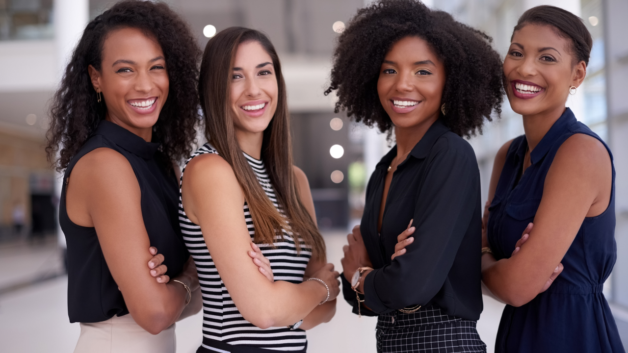 An image of a diverse group of confident women smiling and posing for the camera.