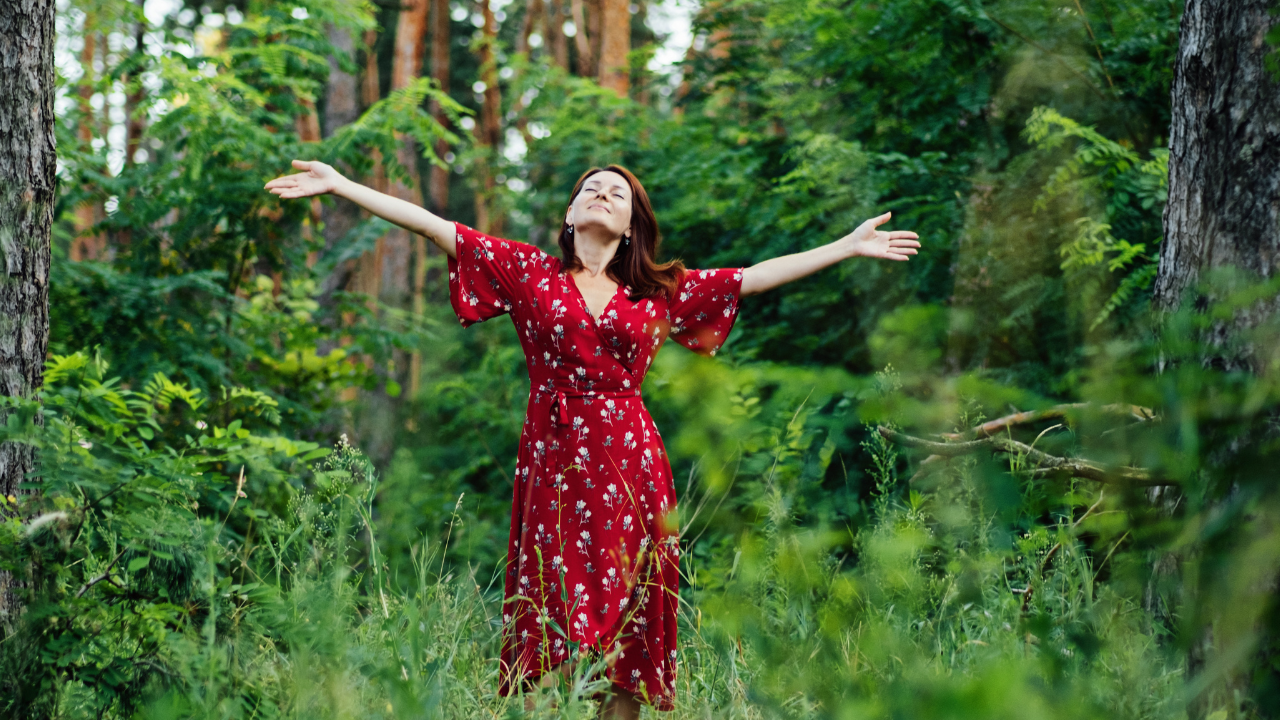 Image of a woman in a red dress enjoying nature.