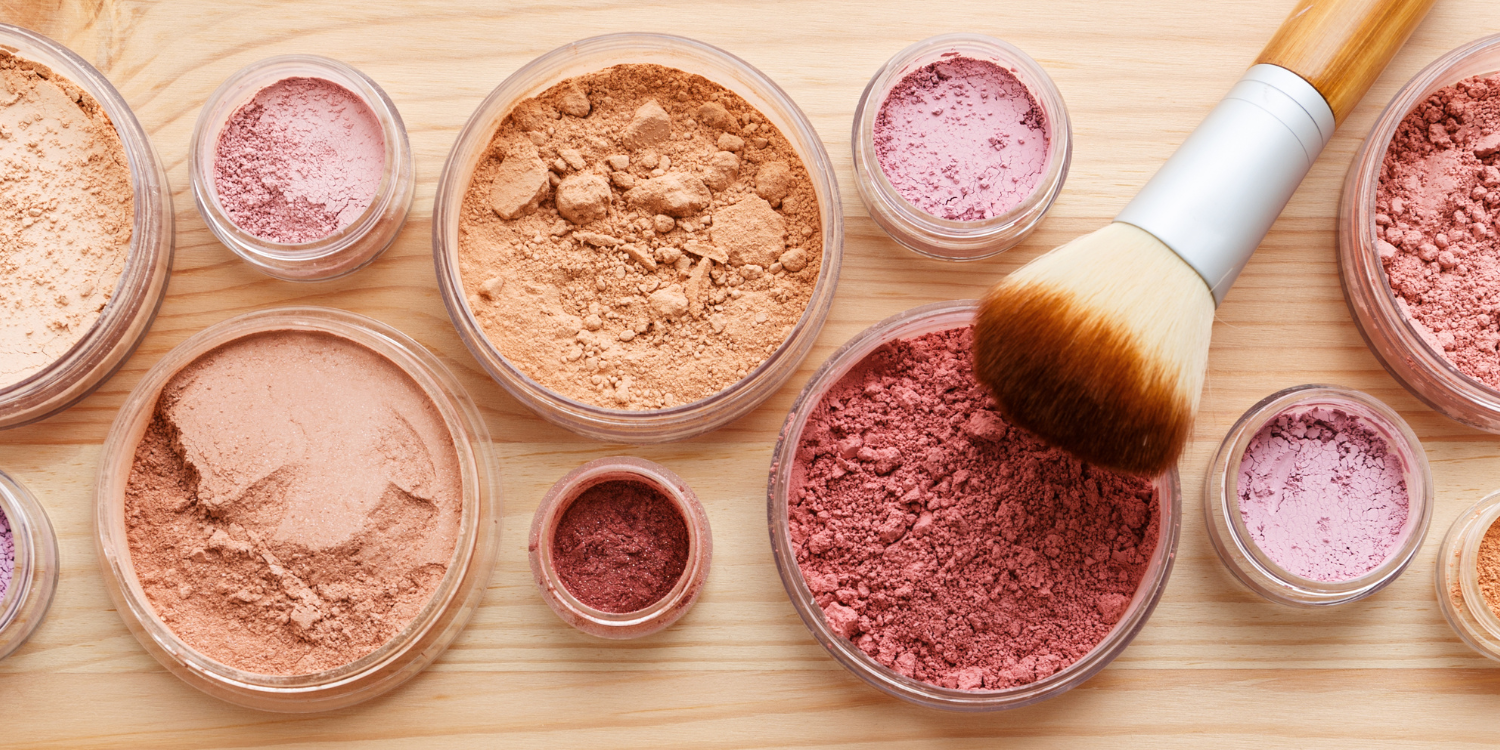 Image of makeup powders alongside a brush. The theme is how to transition your makeup from season to season without spending money.